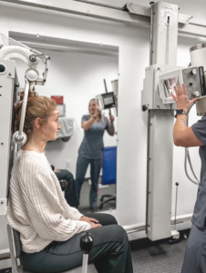Xray 2 x-ray technician adjusting cervical x-ray machine with patient