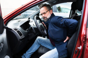 Back Pain Car Driving Injury Man experiencing lower back pain while getting out of a car after an auto accident